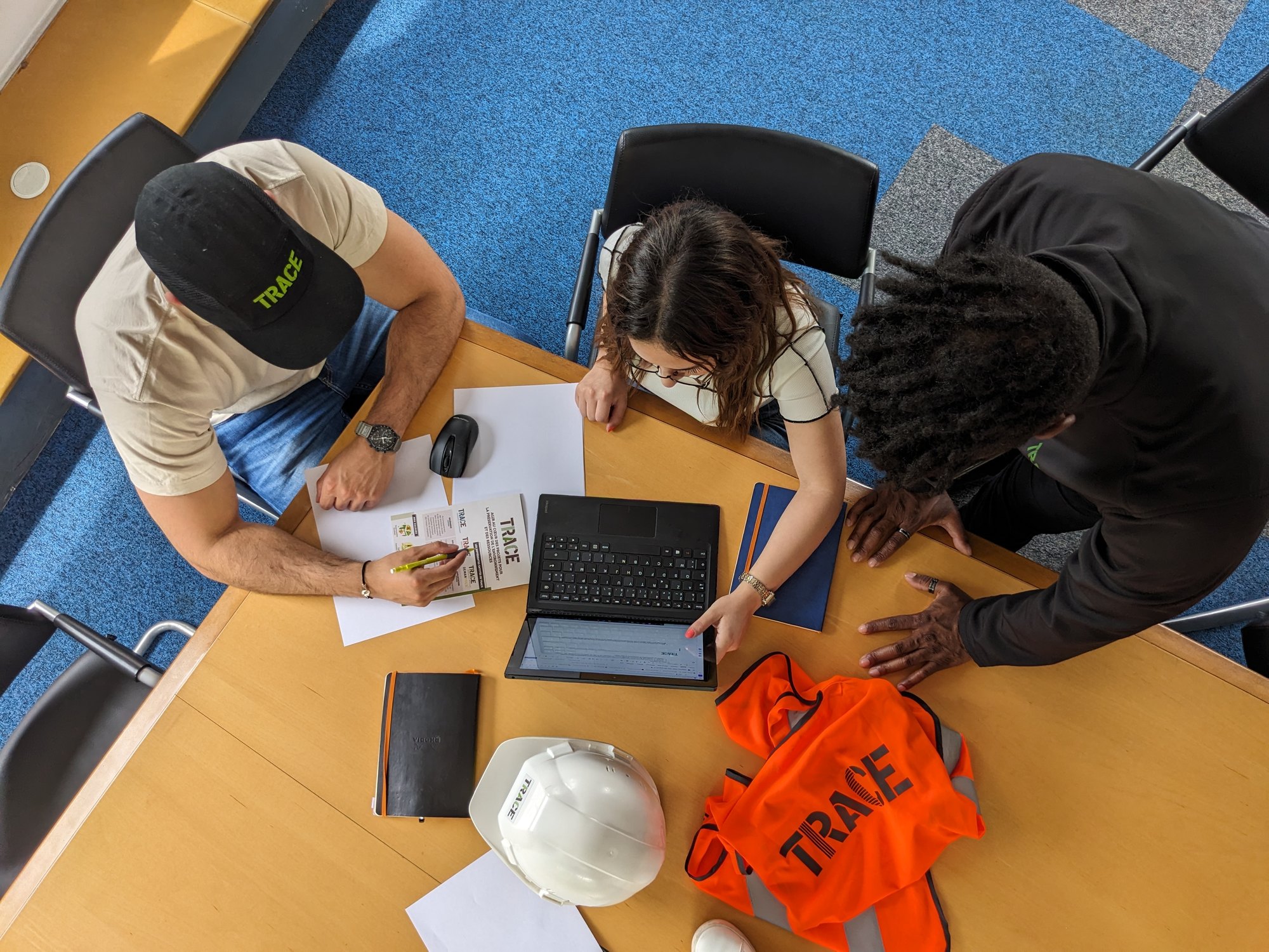 Trois collaborateurs TRACE autour d'une table de travail